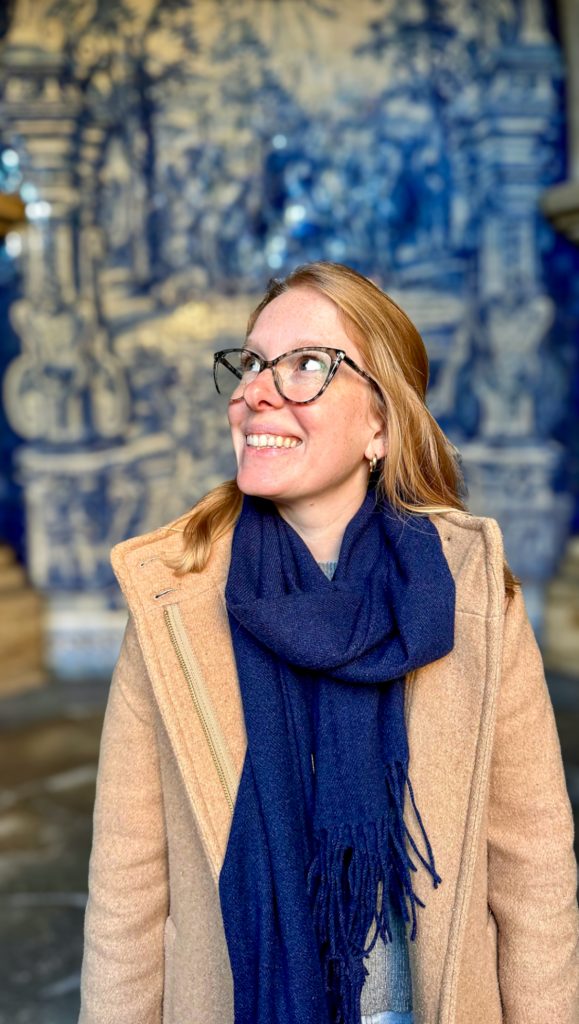 A woman wearing a scarf and hat enjoying winter in Porto, Portugal